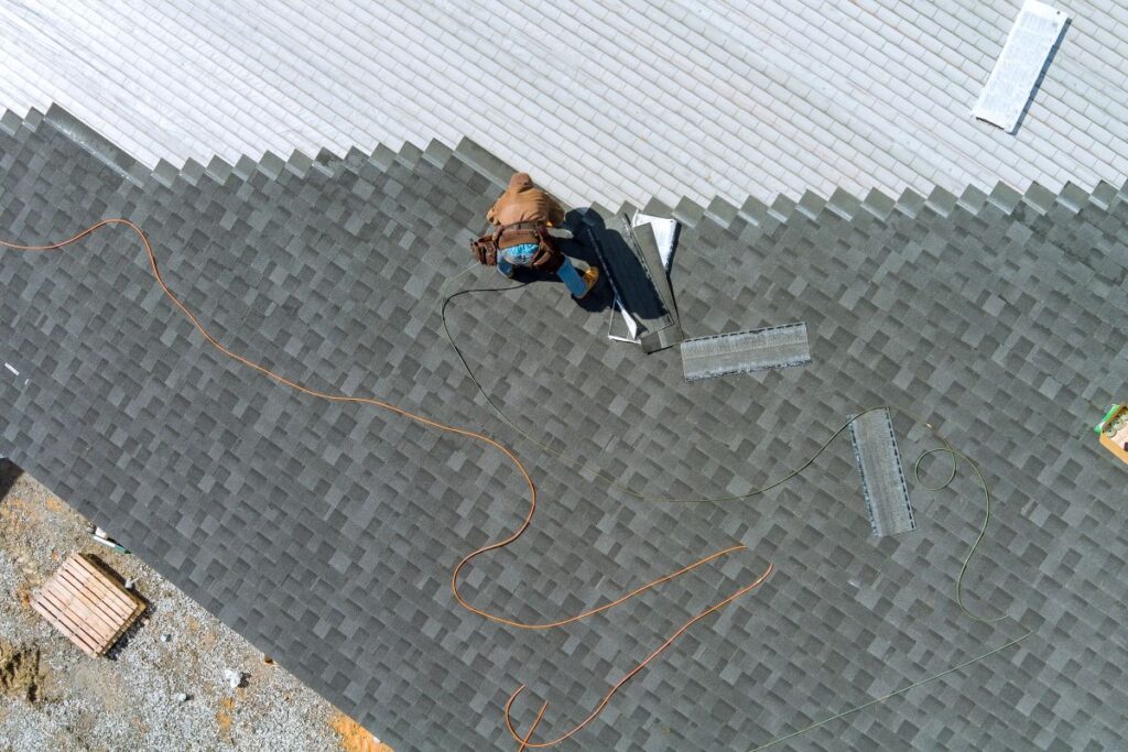 asphalt shingles installation on the roof roofer is nailing asphalt shingles to roofing construction