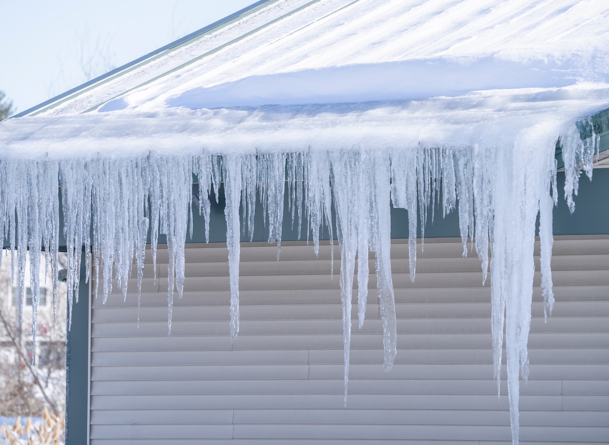 A Minneapolis home with icicles hanging from failed gutters — a classic sign that the gutter system is nearing replacement